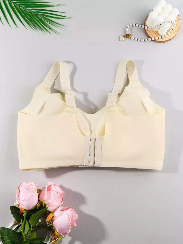 Back view of a beige seamless bra showing the back-fastening hook-and-eye closure and wide comfortable shoulder straps.