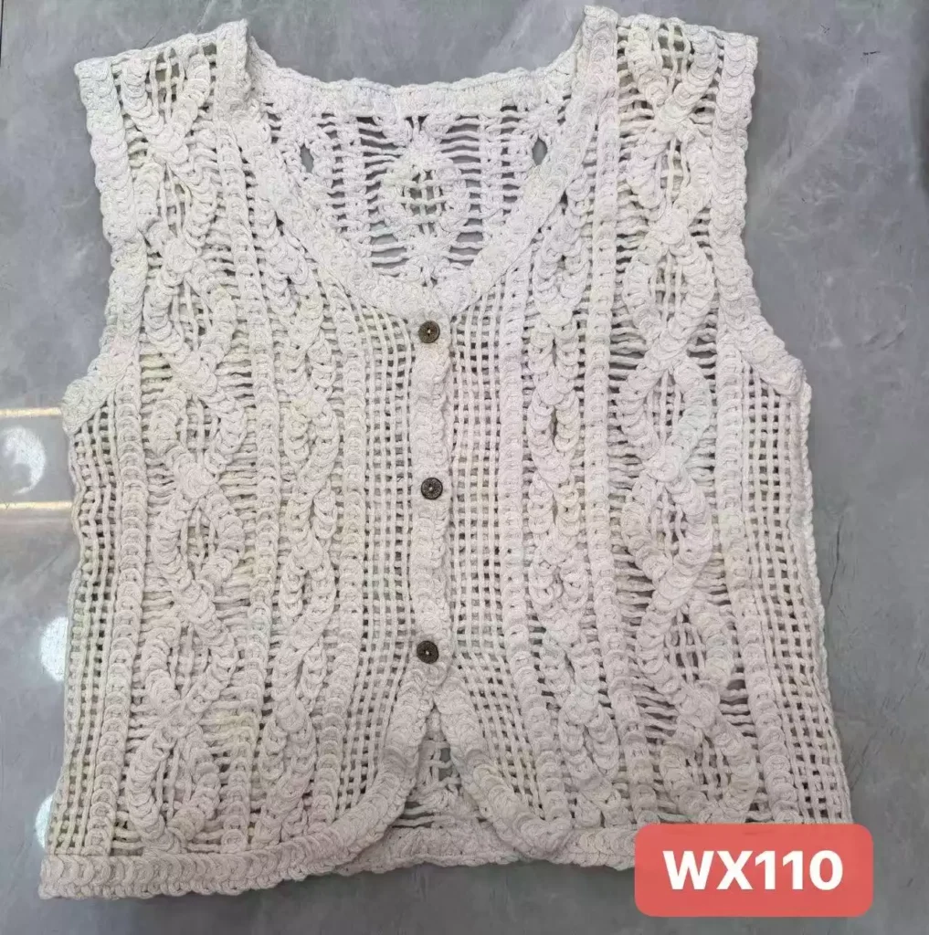 A flat lay of a white braided-pattern crochet vest, showcasing its 3D knit structure and button-front design, style WX110.