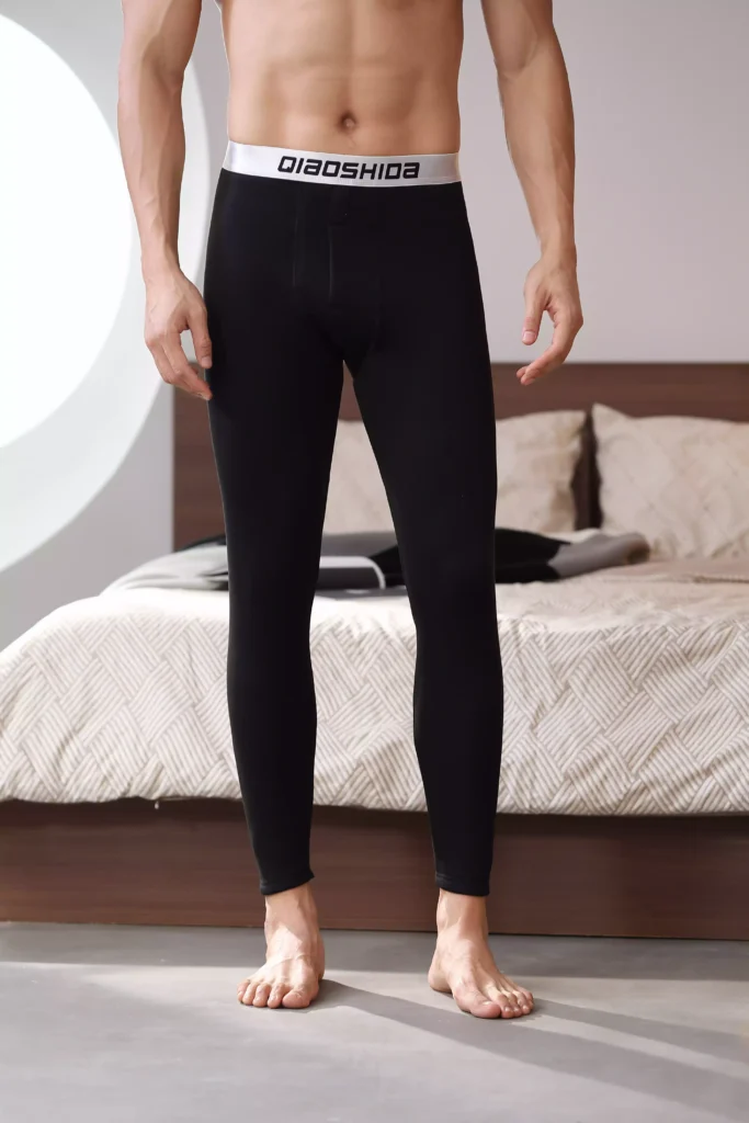 Front view of a man wearing black compression leggings with a branded waistband.