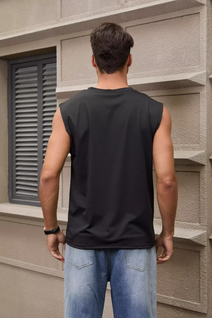 Rear view of a man wearing a black sleeveless muscle tee paired with blue jeans.