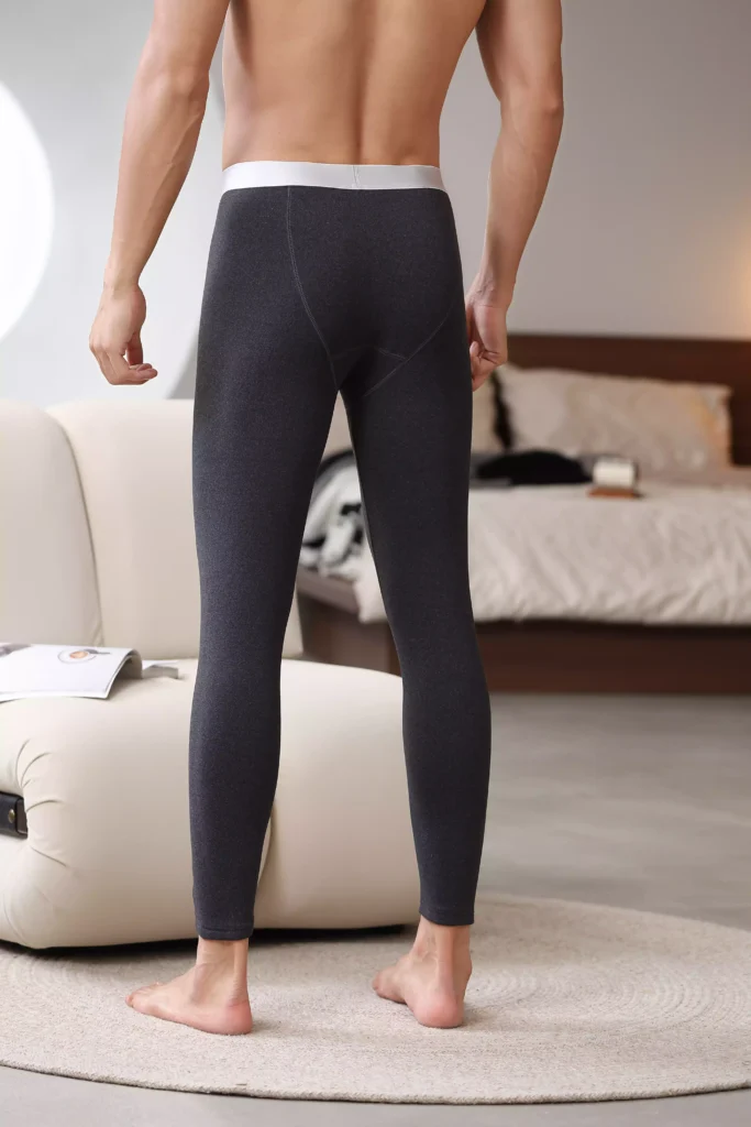 Rear view of a man wearing dark grey compression leggings, showcasing a sleek and fitted design.