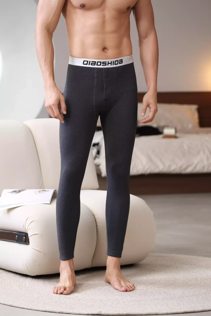 Front view of a man wearing dark grey compression leggings with a branded waistband.