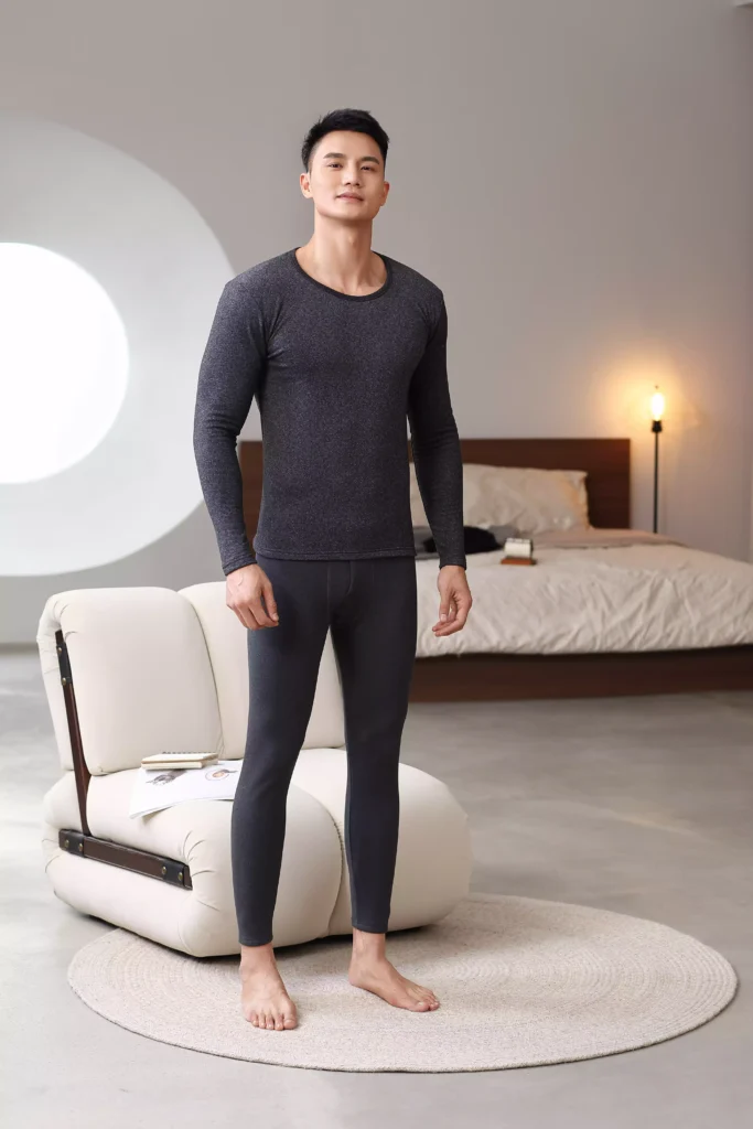 Front view of a man wearing a dark grey thermal underwear set, showcasing a modern, tailored fit.