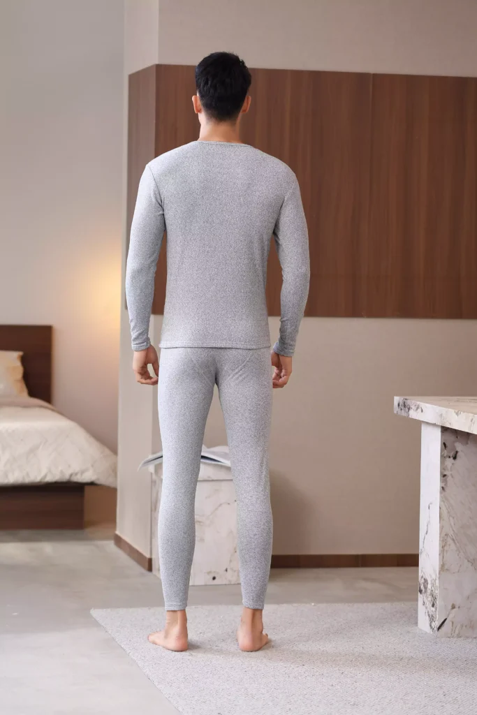 Rear view of a man wearing a grey thermal underwear set, highlighting a sleek and comfortable tailored fit.