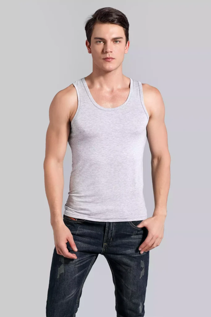 Front view of a man wearing a grey tank top undershirt, showcasing the slim-fit design and high-quality fabric against a grey studio background.
