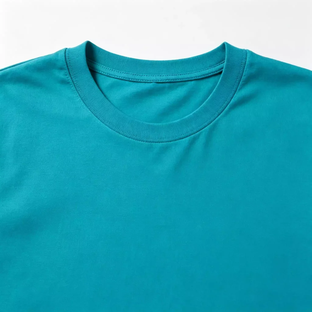 Close-up view of the ribbed neckline and stitching on a premium turquoise men's crew-neck T-shirt, highlighting the smooth cotton fabric texture