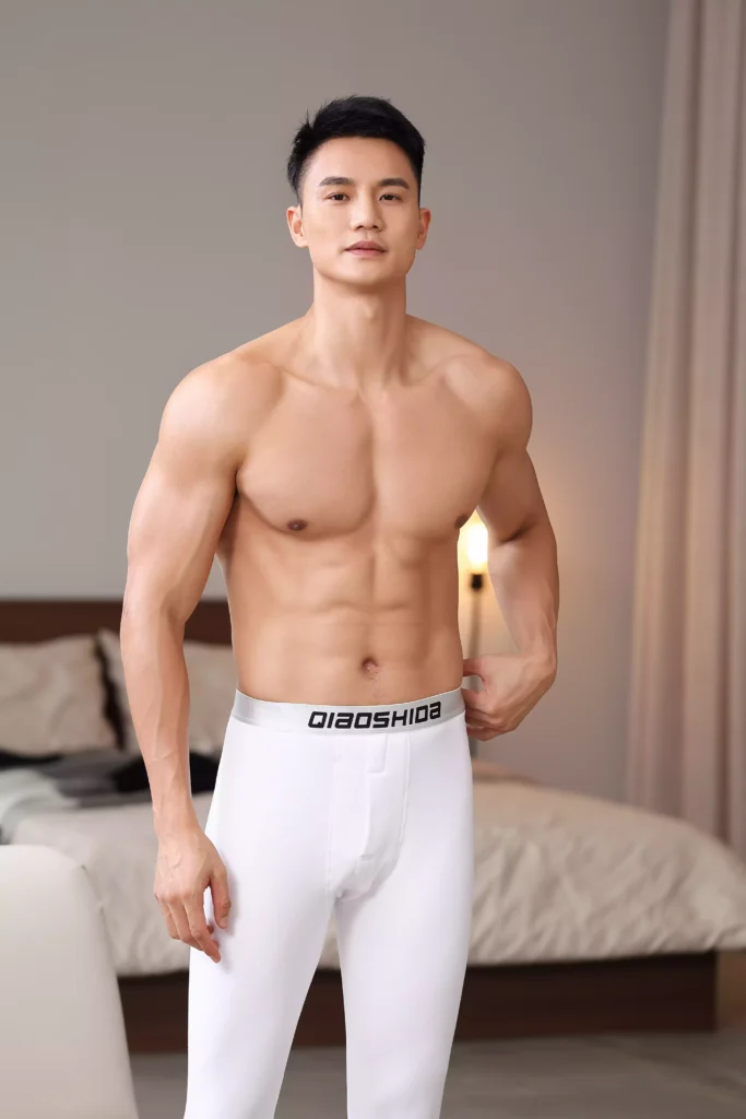 Front view of a muscular man wearing white compression leggings with a branded waistband.