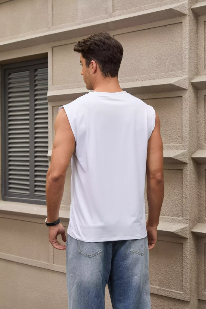 Rear view of a man wearing a white sleeveless muscle tee paired with blue jeans.