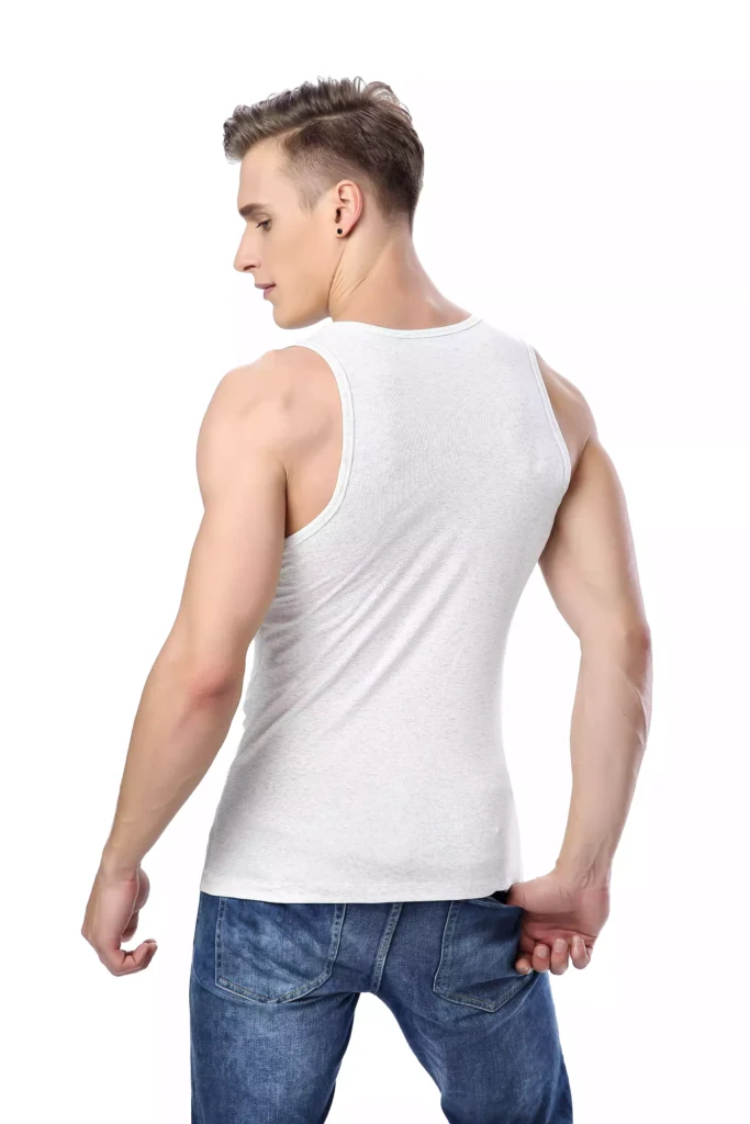 A male model seen from the back, wearing a fitted white cotton tank top and blue jeans, showcasing the shirt's cut and fit.