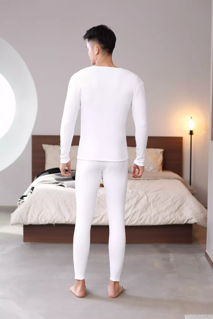 Rear view of a man wearing a white thermal underwear set, highlighting a sleek and comfortable fit.