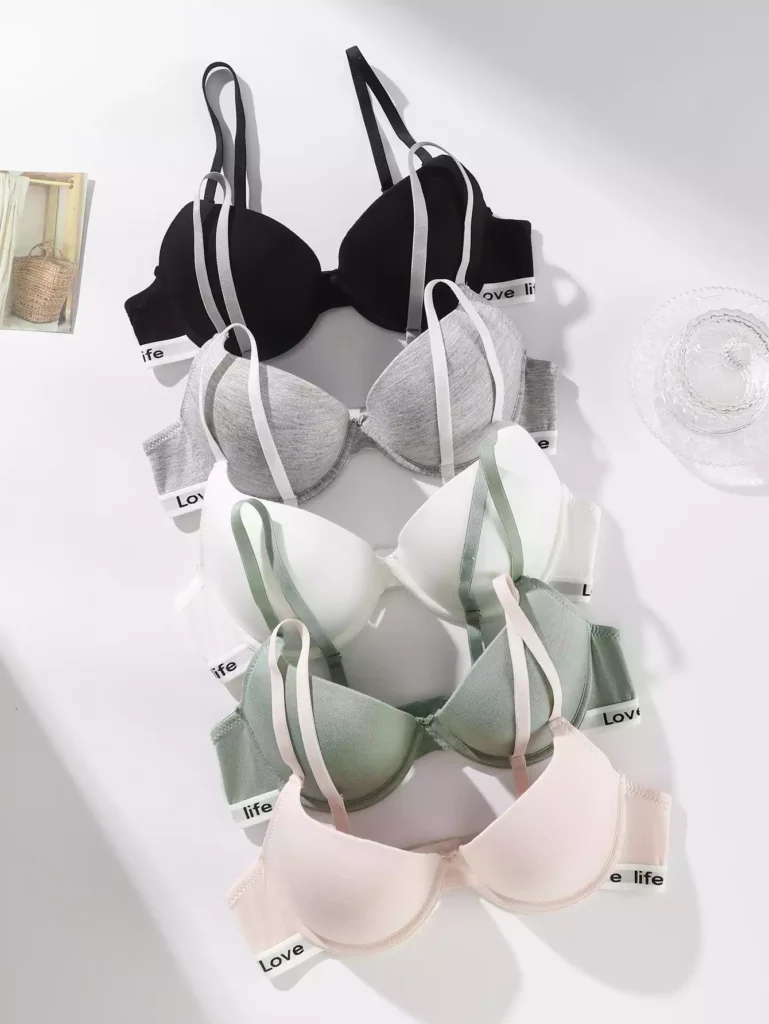 A collection of sports-style bras arranged in a vertical row, featuring various colors like black, grey, white, green, and pink with branded elastic bands.