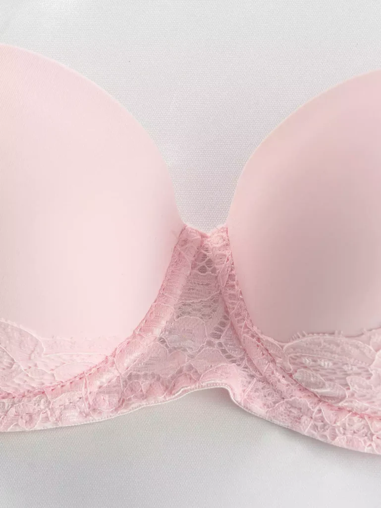 Close-up of the delicate floral lace trim on a soft pink bra cup, highlighting the intricate texture and high-quality craftsmanship.