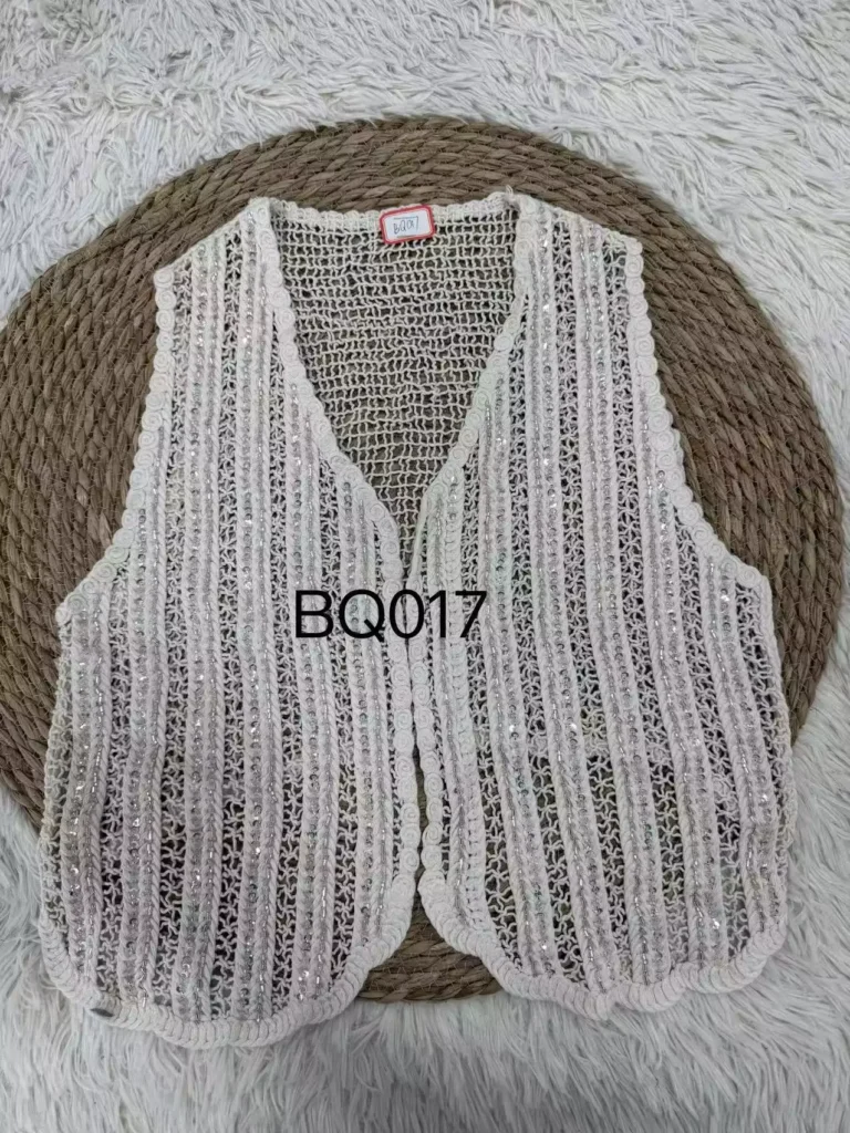 A flat lay product shot of a white vertical-striped crochet vest, featuring sequin accents and intricate crocheted edges, style BQ017.