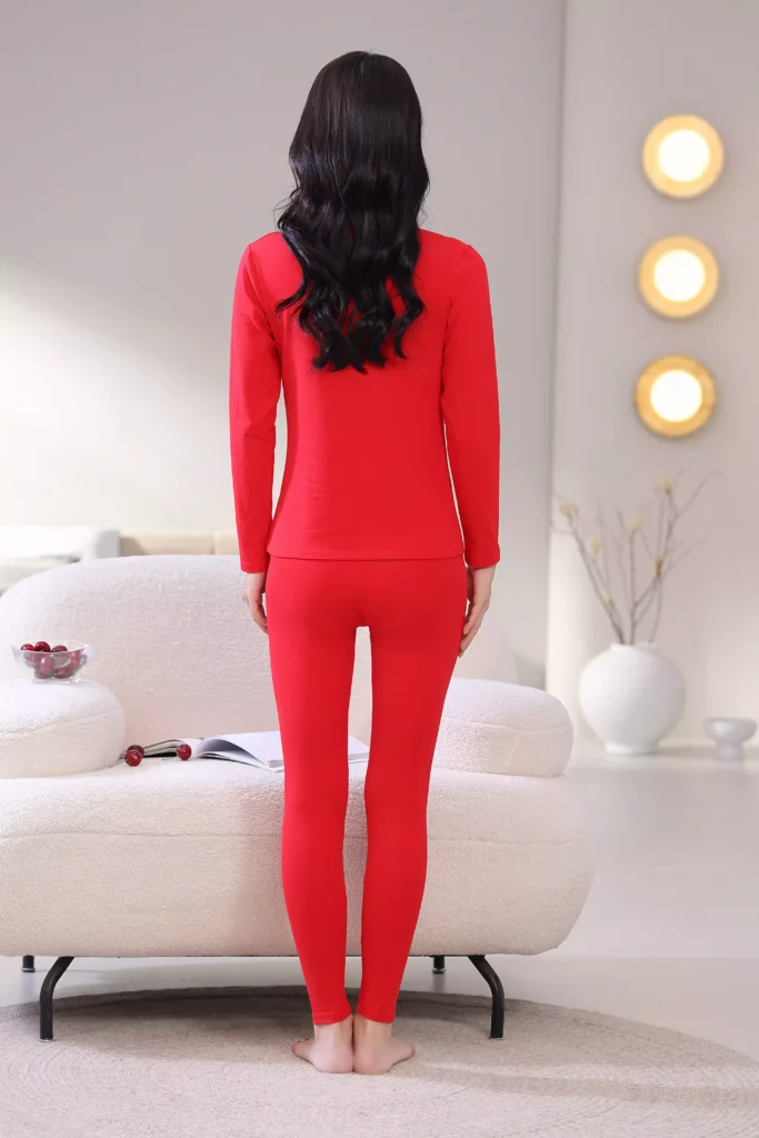 Rear view of a woman wearing a vibrant red long-sleeve thermal set, highlighting the fit and design.